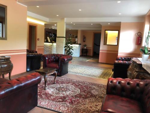 a lobby with leather couches and a rug at Hotel Campo Felice in Lucoli Alto