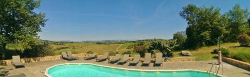 a swimming pool in a yard with lounge chairs at Podere Patrignone in Castellina in Chianti