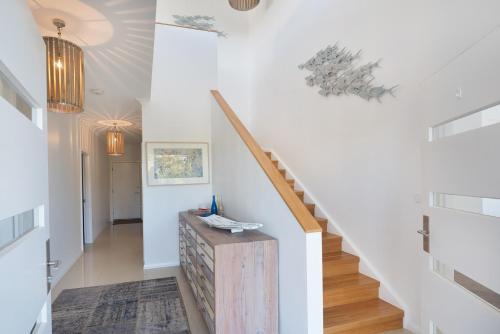a hallway with white walls and stairs with a wooden table at Casa Azzura - beachside entertainer in Dunsborough
