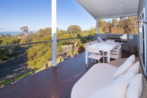 a bedroom with a bed and a table on a balcony at Casa Azzura - beachside entertainer in Dunsborough