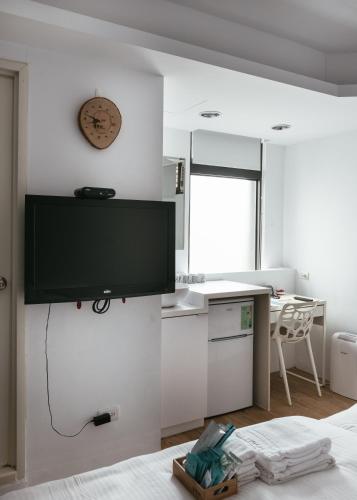 a living room with a tv on the wall at Fengjia Love I Hostel in Taichung