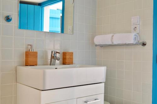 a white bathroom with a sink and a mirror at Vanis House Sunset View Kythira in Kythira