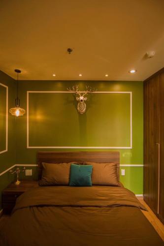 a bedroom with a bed with a green wall at Full House Condotel - Căn hộ 606 Dalat Center in Da Lat