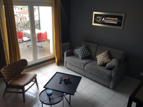 a living room with a couch and a table at Résidence Studio Grand Luxe Wifi parking privé in Vaulx-en-Velin