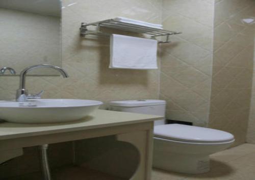 a bathroom with a sink and a toilet at Zhangye Liangmao Hotel in Zhangye
