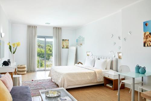 1 dormitorio blanco con 1 cama y sala de estar en Sappho Hotel, en Parga