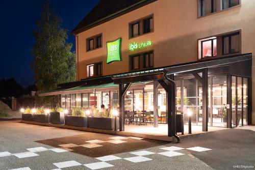 a building with a restaurant with lights in front of it at ibis Styles Bâle-Mulhouse Aéroport in Blotzheim