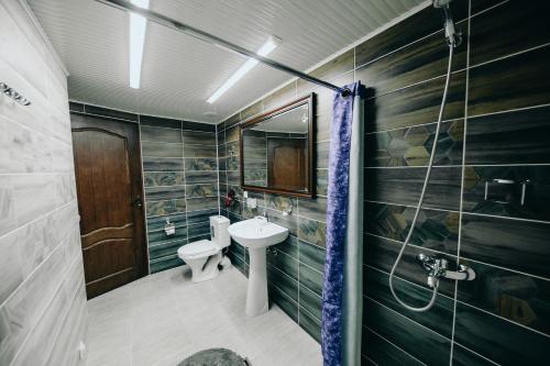 a bathroom with a sink and a toilet and a shower at Club-Hotel Flagman in Bishkek
