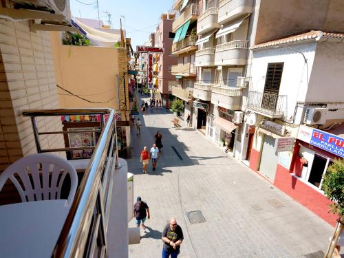 a group of people walking down a street with buildings at Hostal Anna Benidorm in Benidorm