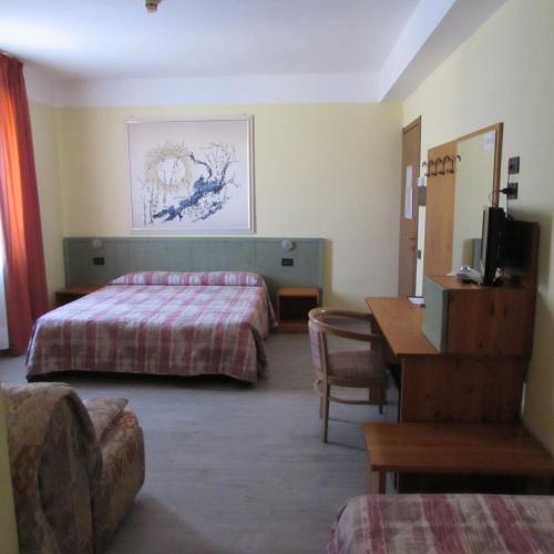 una habitación de hotel con dos camas y una mesa en Hotel Alpi Del Mare, en Mondovì