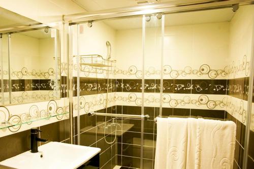 y baño con ducha, lavabo y espejo. en Ching Yeh Hotel, en Xinfeng