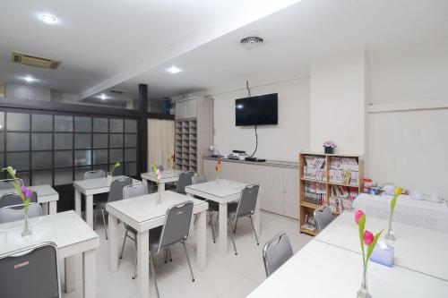 a classroom with tables and chairs and a tv at Blossom Resident Blok M in Jakarta