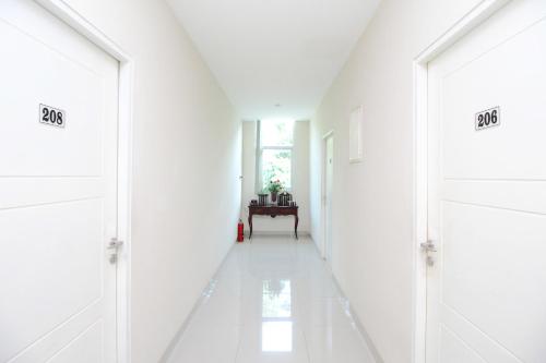 an empty hallway with white walls and white floors at Blossom Resident Blok M in Jakarta