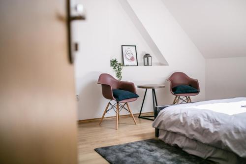 a bedroom with two chairs and a table at Schöndorf Hostel - virtual reception in Bratislava