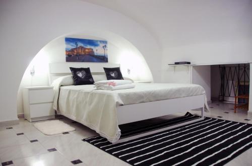 una camera bianca con un grande letto in una stanza di Holiday Home Station a Napoli