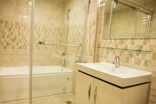 a bathroom with a sink and a shower and a tub at Ching Yeh Hotel in Xinfeng