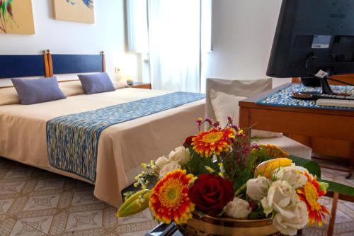 a bouquet of flowers sits on a bed in a hotel room at Hotel Rio Sul Mare in Rio Marina