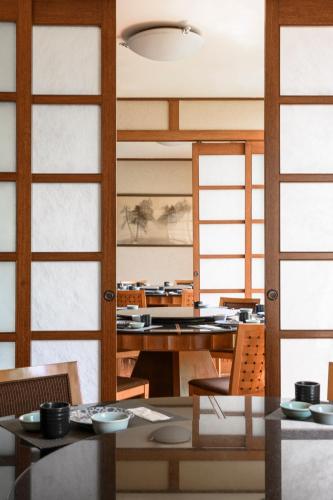 a dining room with wooden doors and tables and chairs at Lakeshore Hotel Hsinchu in Hsinchu City