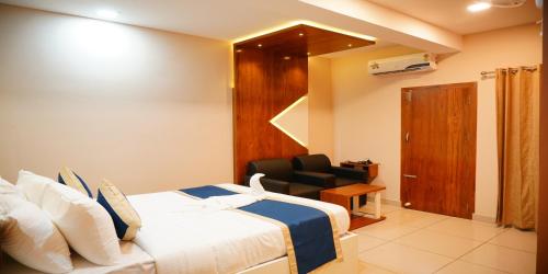 a hotel room with a bed and a chair at Nextel Inn, Calicut in Kozhikode