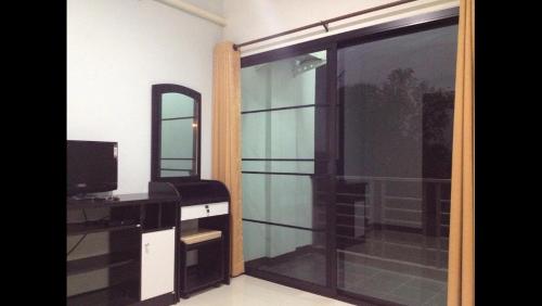 a room with a window and a desk and a television at nana grand in Phrae