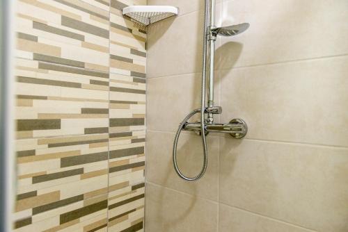 a shower with a shower head in a bathroom at Friday Hotel in Mamaia Nord