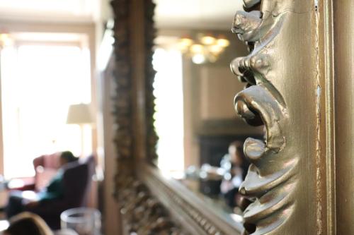 a mirror in a room with people sitting in a room at Causeway Hotel in Bushmills