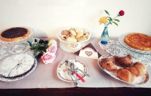 a table topped with plates of pastries and pies at Bed And Breakfast 22 Garibaldi Home in Riccione