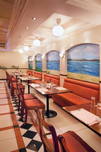 a restaurant with tables and chairs and paintings on the walls at Landmark Hotel in Dubai