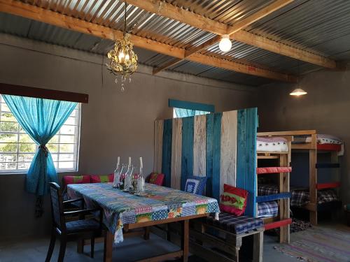 a dining room with a table and chairs and a chandelier at Waterval farmstay in Graaff-Reinet