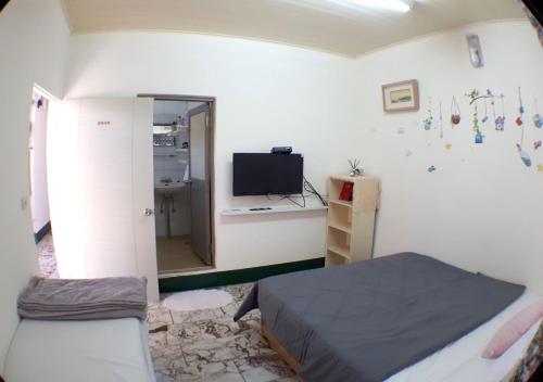 a bedroom with a bed and a tv in a room at Gods Home in Checheng