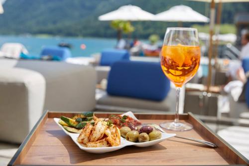 a table with a plate of food and a glass of wine at Entners am See in Pertisau