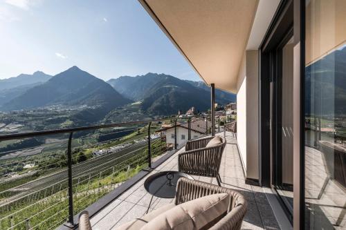 a balcony with chairs and a view of mountains at Prunner Luxury Suites - Adults Only in Schenna