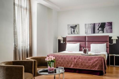 a hotel room with a bed and a table and chairs at Eurostars Roma Aeterna in Rome
