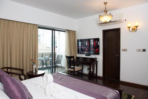 a bedroom with a bed and a desk and a dining room at The Midori by Lakeshore, Gulshan , Dhaka in Dhaka