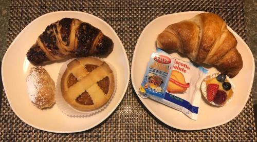 twee borden met croissants en een bagel bij Sunshine-bnb in Aosta
