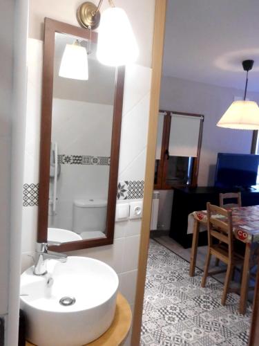 y baño con lavabo, espejo y mesa. en Casa Cardelina, en Camporrells