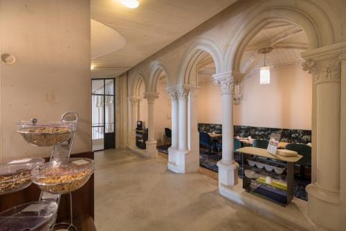 a large room with columns and tables in a building at Mercure Poitiers Centre in Poitiers
