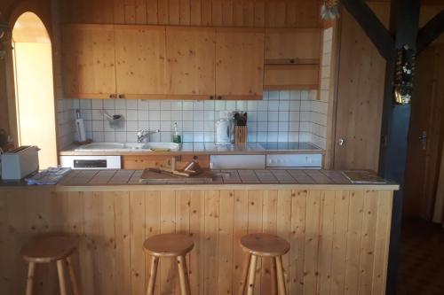 una cucina con 3 sgabelli e bancone di LUMA a Thyon-Les Collons