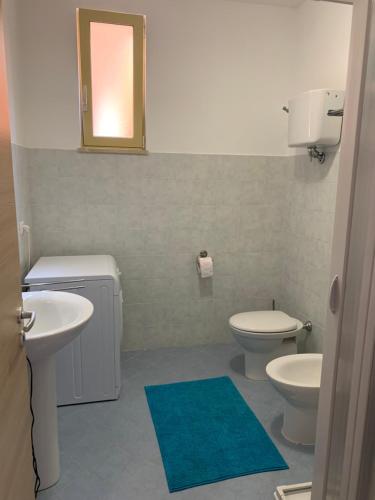 ein Badezimmer mit 2 WCs, einem Waschbecken und einem Spiegel in der Unterkunft Apartment Olga in Pizzo