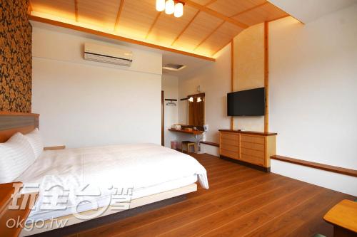 a bedroom with a bed and a flat screen tv at Do Tian Ding B&B in Lugu