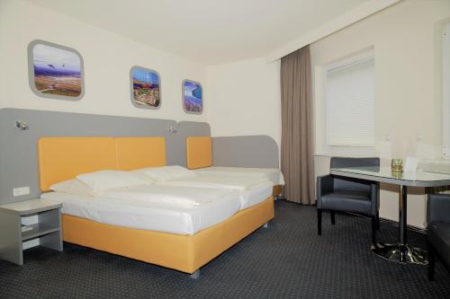 Schlafzimmer mit einem Bett, einem Schreibtisch und einem Tisch in der Unterkunft Hotel Cockpit in Hamburg