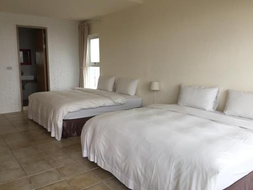 two beds sitting next to each other in a room at Seashore My Home in Eluan
