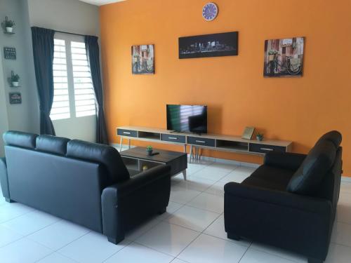 a living room with two couches and a tv at Ipoh Water Front City Homestay in Ipoh
