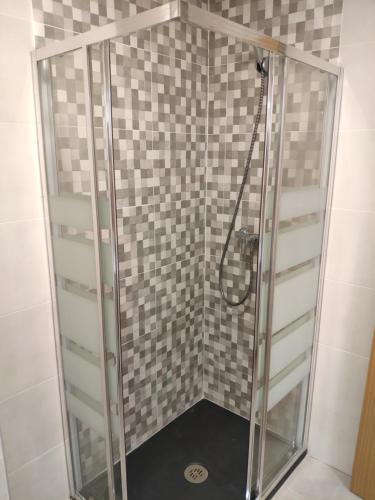 La salle de bains est pourvue d'une douche avec une porte en verre. dans l'établissement Relax and enjoy in brand new beach apartment I, à Los Llanos