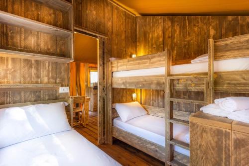 パラッツォーロ・デッロ・ステッラにあるAgriturismo Tenuta Regina - Glamping luxury lodges and apartmentsの木製の壁の客室で、二段ベッド2組が備わります。