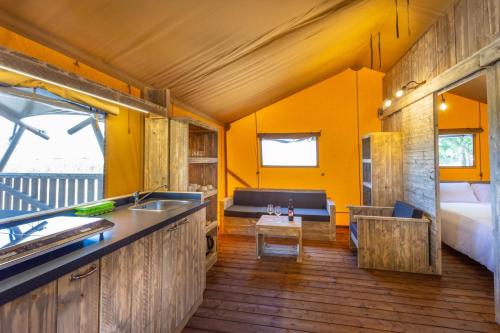 una cocina y sala de estar en una casa pequeña en Agriturismo Tenuta Regina - Glamping luxury lodges and apartments, en Palazzolo dello Stella