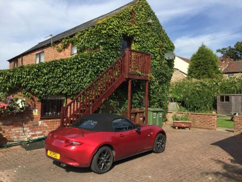 a red car parked in front of a house at RolandsCroft Guest House in Pontefract