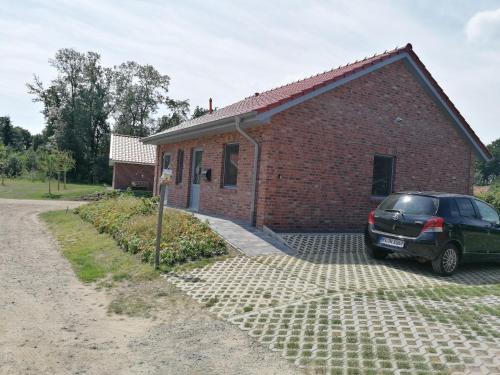 a car parked in front of a brick building at Holunder Hüsken in Oberlangen