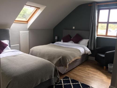 - une chambre mansardée avec 2 lits et une fenêtre dans l'établissement Shannon's House, à Doolin