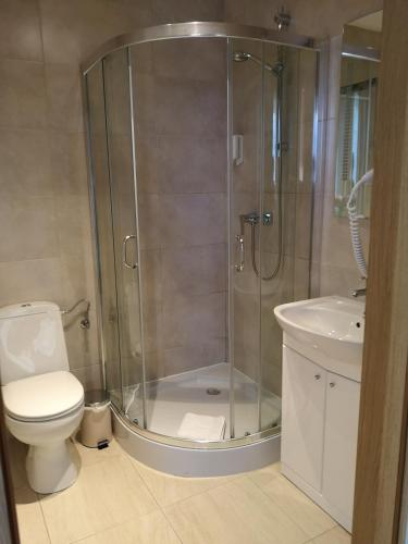 a bathroom with a shower and a toilet and a sink at Riviera Resort Airport Modlin in Olszewnica Nowa